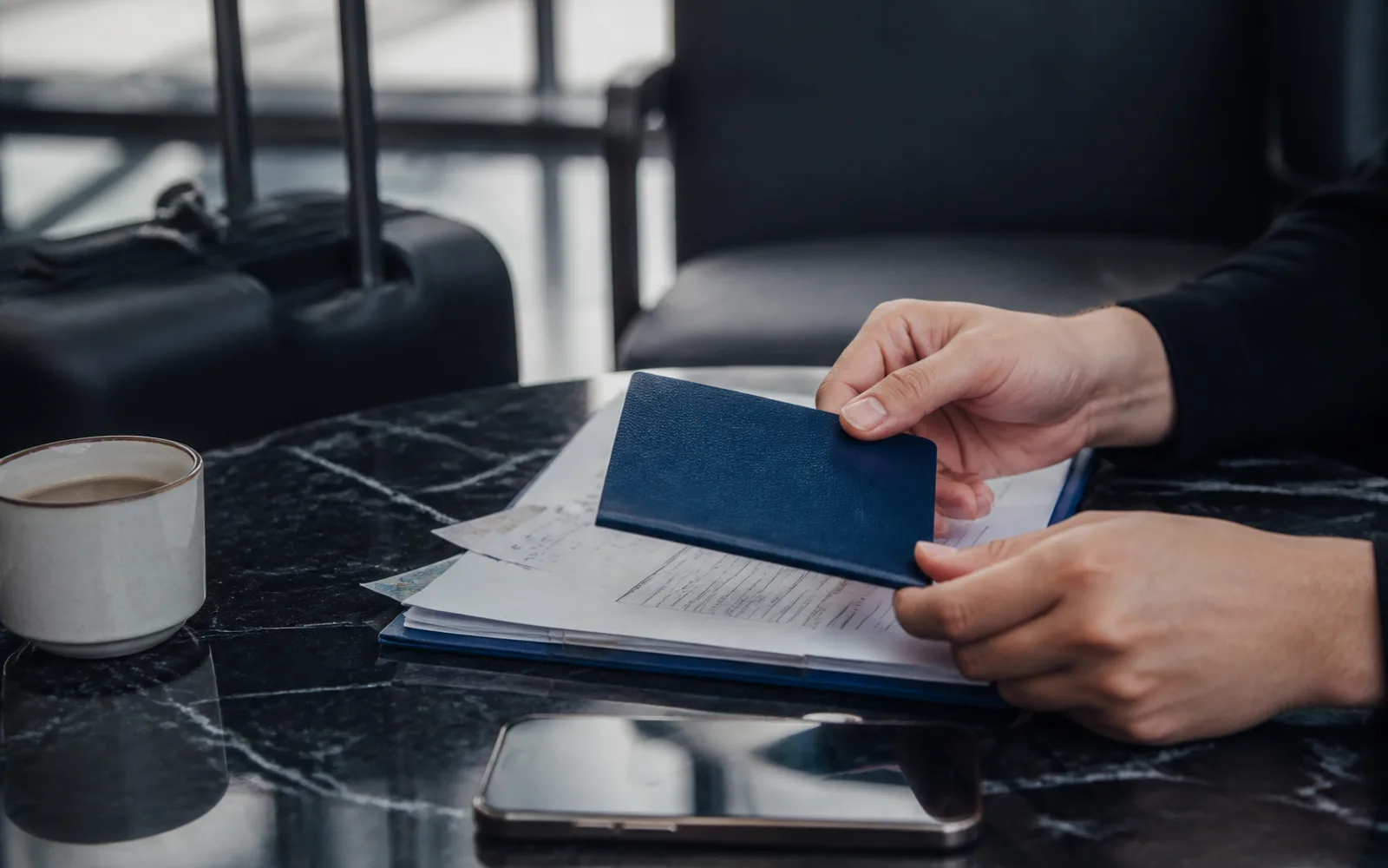 Passport and travel documents being prepared in an airport lounge